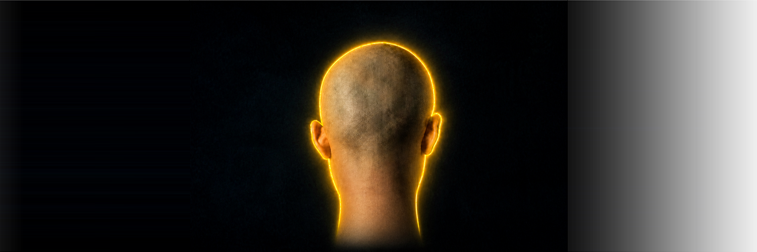 A single bald head glowing against a dark background